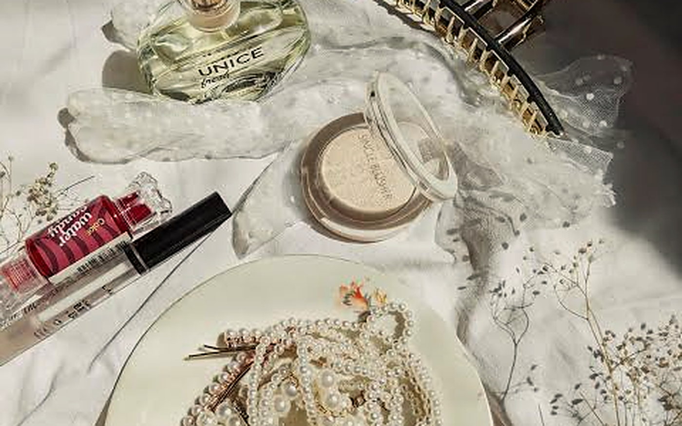 Perfume, oil and cosmetics arranged on a dark surface